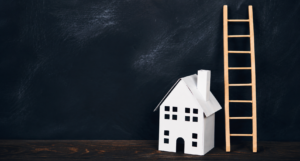 Model house beside a wooden ladder representing the Chester property ladder